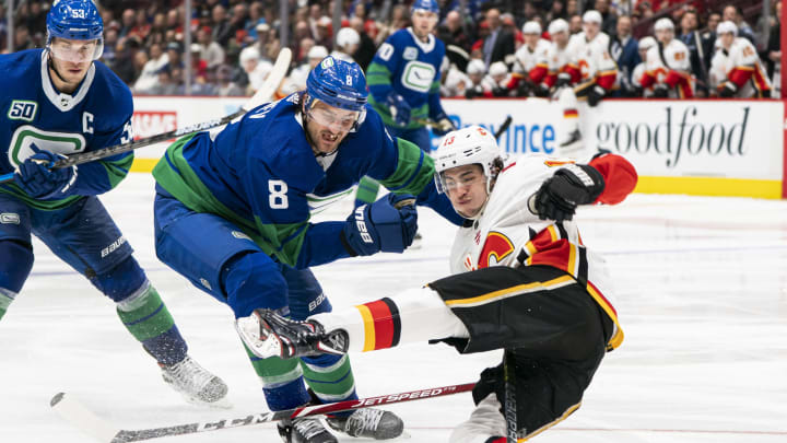 Christopher Tanev of the Vancouver Canucks knocks down Johnny Gaudreau. (Photo by Rich Lam/Getty Images)