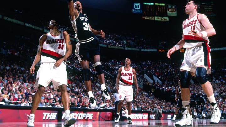 PORTLAND, OR – JUNE 6: Sean Elliot #32 of the San Antonio Spurs shoots a layup against Rasheed Wallace #30 and Arvydas Sabonis #11 of the Portland Trail Blazers in Game Four of the Western Conference Finals during the 1999 NBA Playoffs at the Rose Garden Arena on June 6, 1999 in Portland, Oregon. The Spurs defeated the Blazers 94-80. NOTE TO USER: User expressly acknowledges and agrees that, by downloading and or using this photograph, User is consenting to the terms and conditions of the Getty Images License Agreement. Mandatory Copyright Notice: Copyright 1999 NBAE (Photo by Andrew D. Bernstein/NBAE via Getty Images)