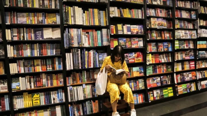 A woman reads a book at a bookstore in Bangkok on June 16, 2019. (Photo by Candida NG / AFP) (Photo credit should read CANDIDA NG/AFP via Getty Images)