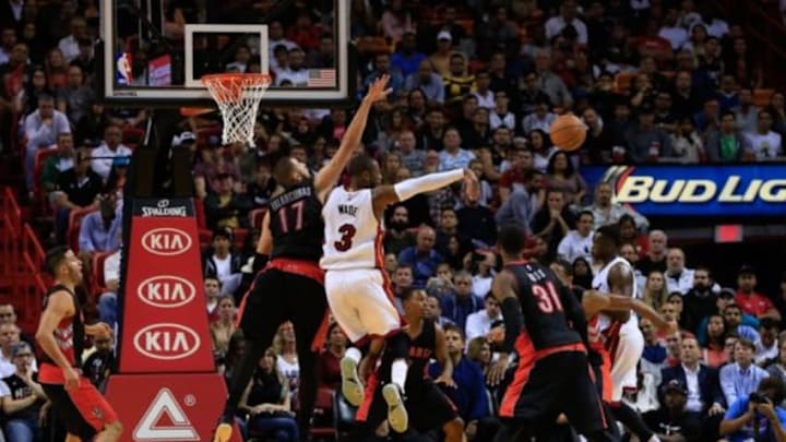 Nov 2, 2014; Miami, FL, USA; Miami Heat guard Dwyane Wade (3) passes the ball as Toronto Raptors center Jonas Valanciunas (17) defends in the first half at American Airlines Arena. Mandatory Credit: Robert Mayer-USA TODAY Sports