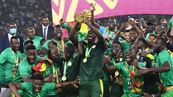 Senegal's players celebrate with the trophy after winning the Africa Cup of Nations (CAN) 2021 final football match between Senegal and Egypt at Stade d'Olembe in Yaounde on February 6, 2022. (Photo by CHARLY TRIBALLEAU / AFP) (Photo by CHARLY TRIBALLEAU/AFP via Getty Images)