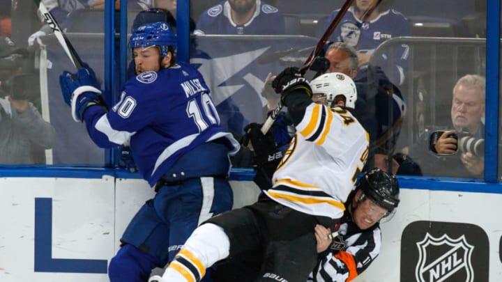 TAMPA, FL - APRIL 30: J.T. Miller #10 of the Tampa Bay Lightning checks Jake DeBrusk #74 of the Boston Bruins into referee Kelly Sutherland #11 during Game Two of the Eastern Conference Second Round during the 2018 NHL Stanley Cup Playoffs at Amalie Arena on April 30, 2018 in Tampa, Florida. (Photo by Mike Carlson/NHLI via Getty Images)