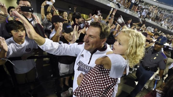 Oct 11, 2014; Starkville, MS, USA; Mississippi State Bulldogs head coach Dan Mullen with his daughter Breelyn Mullen celebrate their 38-23 victory over the Auburn Tigers at Davis Wade Stadium. Mandatory Credit: John David Mercer-USA TODAY Sports