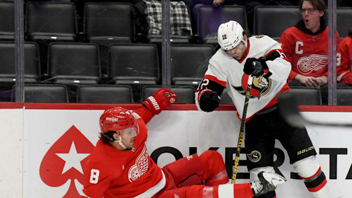 Dec 17, 2022; Detroit, Michigan, USA; Detroit Red Wings defenseman Ben Chiarot (8) is checked to the ice by Ottawa Senators right winger Alex DeBrincat (12) in the first period at Little Caesars Arena. Mandatory Credit: Lon Horwedel-USA TODAY Sports