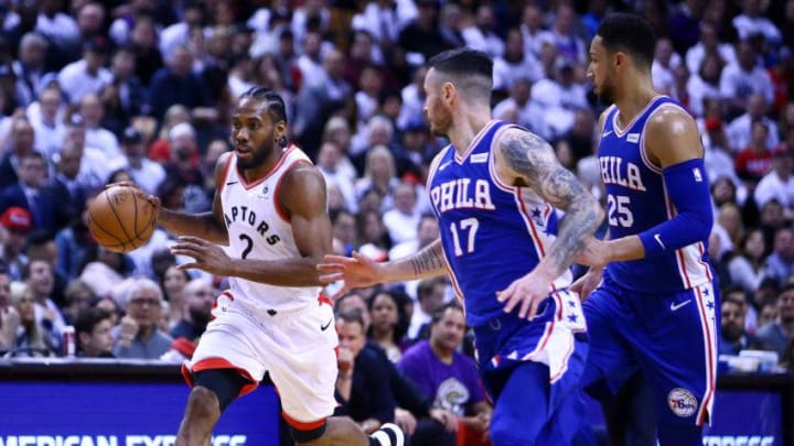 Kawhi Leonard #2 of the Toronto Raptors dribbles the ball as JJ Redick #17 and Ben Simmons #25 of the Philadelphia 76ers. (Photo by Vaughn Ridley/Getty Images)