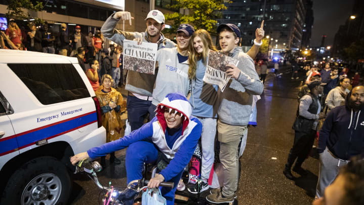 WASHINGTON, DC – OCTOBER 30: Washington Nationals fans pose for a photograph with a pedicab drive dressed in a Baby Shark costume with the front page of the Washington Post outside of Nationals Park as they celebrate the Nationals World Series victory on October 30, 2019 in Washington, DC. The Washington Nationals defeated the Houston Astros 6-2 in Game 7 of the World Series bringing home the first World Series Championship in franchise history and the first to Washington, DC since 1924. (Photo by Samuel Corum/Getty Images)