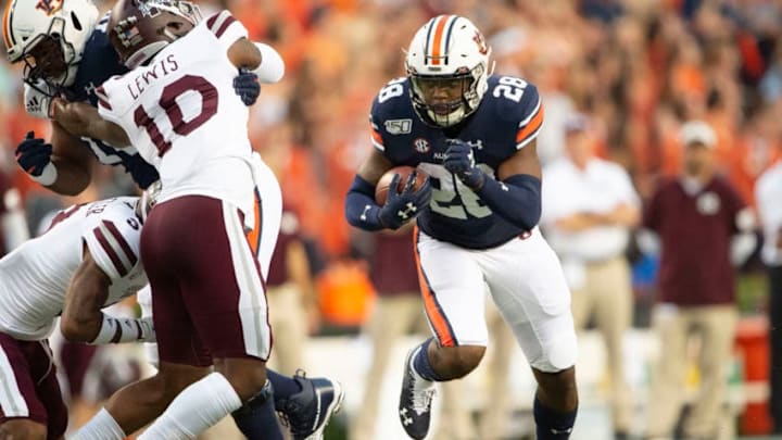 AUBURN, AL - SEPTEMBER 28: Running back JaTarvious Whitlow #28 of the Auburn Tigers looks to run the ball by linebacker Leo Lewis #10 of the Mississippi State Bulldogs during the first quarter at Jordan-Hare Stadium on September 28, 2019 in Auburn, AL. (Photo by Michael Chang/Getty Images)