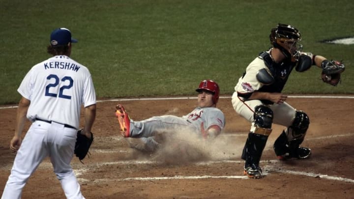 Jul 14, 2015; Cincinnati, OH, USA; American League outfielder Mike Trout (27) of the Los Angeles Angels slides home to score against National League catcher Buster Posey (28) of the San Francisco Giants as National League pitcher Clayton Kershaw (22) of the looks on during the fifth inning of the 2015 MLB All Star Game at Great American Ball Park. Mandatory Credit: David Kohl-USA TODAY Sports