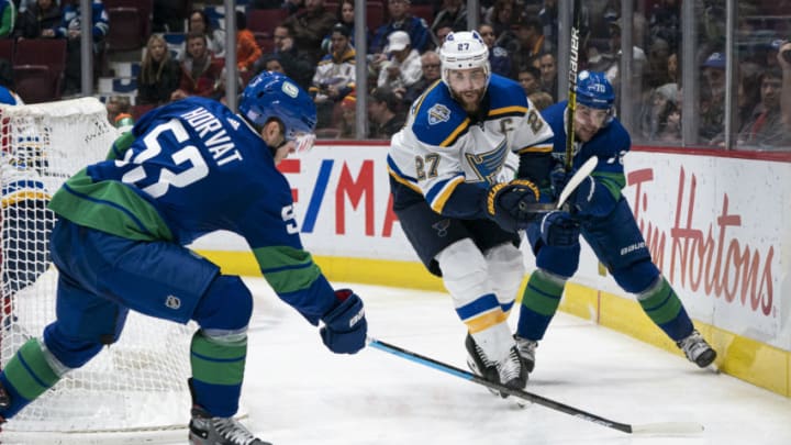 VANCOUVER, BC - NOVEMBER 05: Alex Pietrangelo #27 of the St. Louis Blues moves the pucks past Bo Horvat #53 of the Vancouver Canucks while being checked by Tanner Pearson #70 at Rogers Arena on November 5, 2019 in Vancouver, Canada. (Photo by Rich Lam/Getty Images)