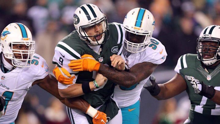 Dec 17, 2016; East Rutherford, NJ, USA; New York Jets quarterback Bryce Petty (9) is hit after throwing a pass by Miami Dolphins defensive end Andre Branch (50) during the first quarter at MetLife Stadium. Mandatory Credit: Brad Penner-USA TODAY Sports