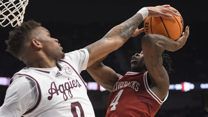 Mar 10, 2023; Nashville, TN, USA; Texas A&M Aggies guard Dexter Dennis (0) blocks the shot of Arkansas Razorbacks guard Davonte Davis (4) during the first half at Bridgestone Arena. Mandatory Credit: Steve Roberts-USA TODAY Sports