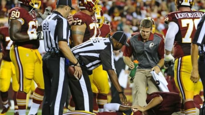 Aug 20, 2015; Landover, MD, USA; Washington Redskins quarterback Robert Griffin III (10) is looked at by trainers after suffering an apparent injury against the Detroit Lions during the first half at FedEx Field. Mandatory Credit: Brad Mills-USA TODAY Sports