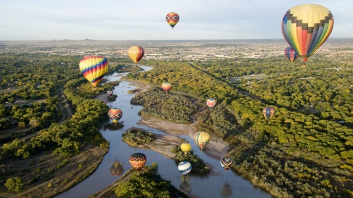 Hot air balloons drifting over the Rio Grande River in Albuquerque, New Mexico.