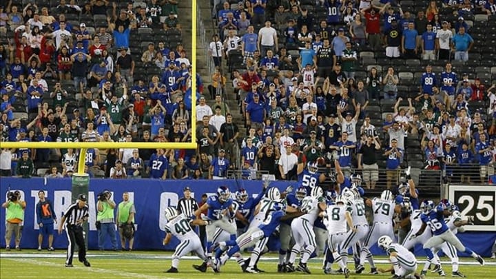Aug 24, 2013; East Rutherford, NJ, USA; New York Jets place kicker Billy Cundiff (8) kicks winning field goal against the New York Giants in OT at MetLife Stadium. New York Jets defeat the New York Giants 24-21 in OT. Mandatory Credit: Jim O