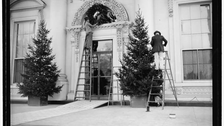 Workers put Christmas decorations on the front of the White House in 1939, during President Franklin Roosevelt's second term.