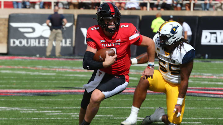 Oct 22, 2022; Lubbock, Texas, USA; Texas Tech Red Raiders quarterback Behren Morton (2) rushes against West Virginia Mountaineers defensive tackle Dante Stills (55) in the first half at Jones AT&T Stadium and Cody Campbell Field. Mandatory Credit: Michael C. Johnson-USA TODAY Sports