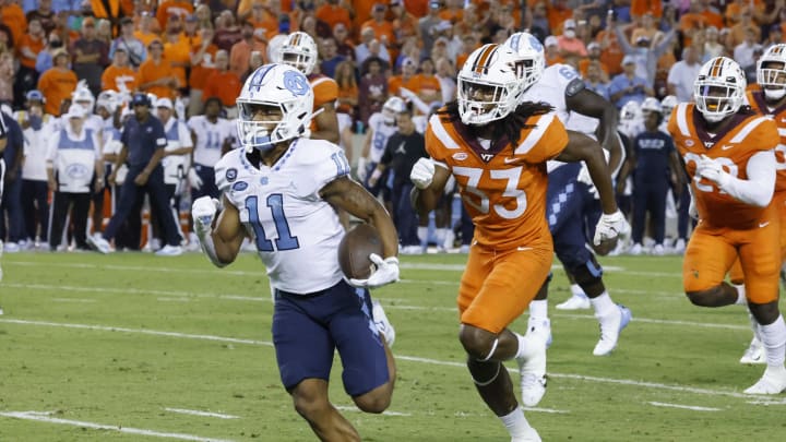 Sep 3, 2021; Blacksburg, Virginia, USA; North Carolina Tar Heels wide receiver Josh Downs (11) gets past Virginia Tech Hokies defensive back Keonta Jenkins (33) and runs in for a touchdown during the second half at Lane Stadium. Mandatory Credit: Reinhold Matay-USA TODAY Sports