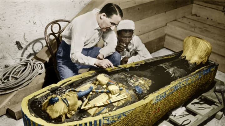 English Egyptologist Howard Carter examines the golden sarcophagus of King Tutankhamun in Egypt in 1923.