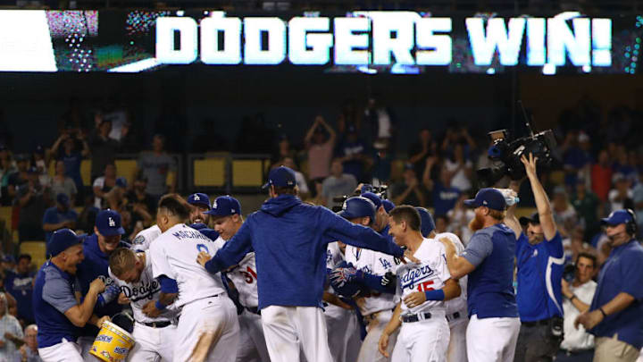 LOS ANGELES, CA - AUGUST 01: Yasmani Grandal #9 of the Los Angeles Dodgers (third from left) is mobbed by teammates after Grandal hit a two-run walk-off homerun over the right field fence in the tenth inning of the MLB game against the Milwaukee Brewers at Dodger Stadium on August 1, 2018 in Los Angeles, California. The Dodgers defeated the Brewers 6-4. (Photo by Victor Decolongon/Getty Images)