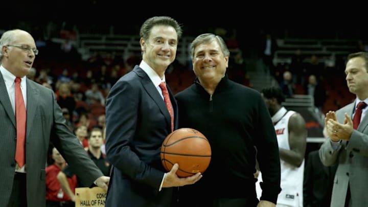 LOUISVILLE, KY - NOVEMBER 26: Rick Pitino the head coach of the Louisville Cardinals is presented with a game ball by athletic director Tom Jurich after the game against the Cleveland State Vikings at KFC YUM! Center on November 26, 2014 in Louisville, Kentucky. With tonights 45-33 win Pitino won his 700th careercollegiate game. (Photo by Andy Lyons/Getty Images)