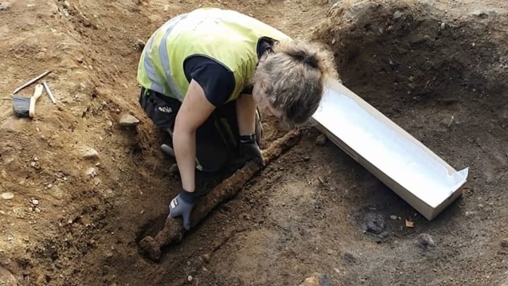 NTNU archaeologist Astrid Kviseth digs up a viking sword in Norway.