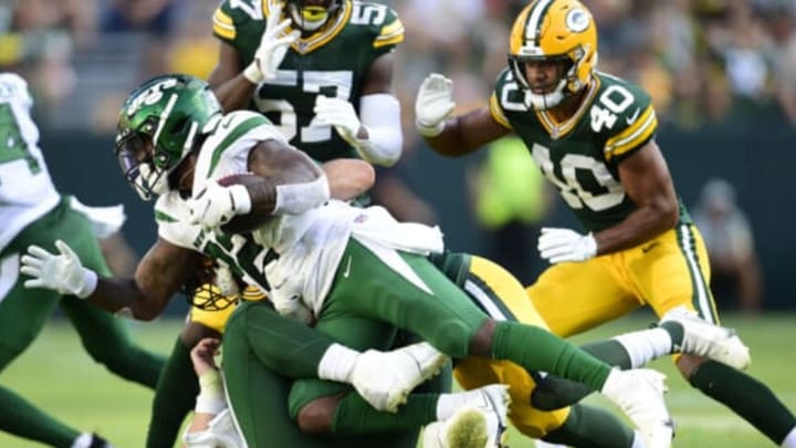 GREEN BAY, WISCONSIN – AUGUST 21: La’Mical Perine #22 of the New York Jets is tackled by Isaiah McDuffie #58 of the Green Bay Packers in the second half of a preseason game at Lambeau Field on August 21, 2021 in Green Bay, Wisconsin. (Photo by Patrick McDermott/Getty Images)