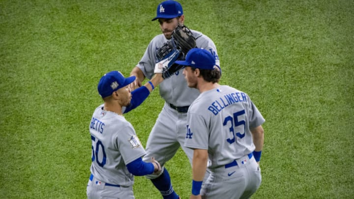 Oct 25, 2020; Arlington, Texas, USA; Los Angeles Dodgers right fielder Mookie Betts (50) and center fielder Cody Bellinger (35) and left fielder Chris Taylor (3) celebrate the win over the Tampa Bay Rays in game five of the 2020 World Series at Globe Life Field. Mandatory Credit: Jerome Miron-USA TODAY Sports