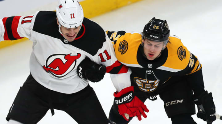 BOSTON - DECEMBER 27: Boston Bruins' Brandon Carlo holds on to the arm of the Devils' Brian Boyle as they chase a loose puck in the first period. The Boston Bruins host the New Jersey Devils in a regular season NHL hockey game at TD Garden in Boston on Dec. 27, 2018. (Photo by John Tlumacki/The Boston Globe via Getty Images)
