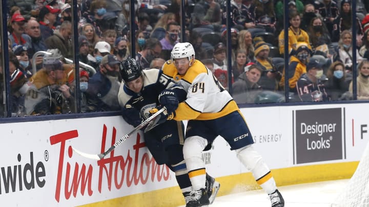Dec 30, 2021; Columbus, Ohio, USA; Nashville Predators left wing Tanner Jeannot (84) checks Columbus Blue Jackets center Jack Roslovic (96) during the first period at Nationwide Arena. Mandatory Credit: Russell LaBounty-USA TODAY Sports