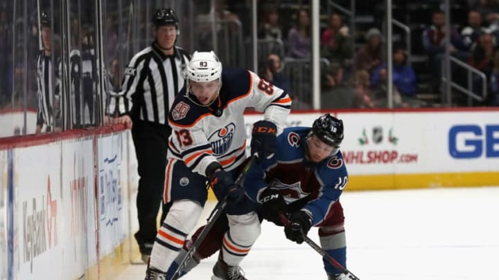 DENVER, COLORADO - DECEMBER 11: Matt Benning #83 of the Edmonton Oilers fights for control of the puck against Sven Andringhetto #10 of the Colorado Avalanche in the third period at the Pepsi Center on December 11, 2018 in Denver, Colorado. (Photo by Matthew Stockman/Getty Images)