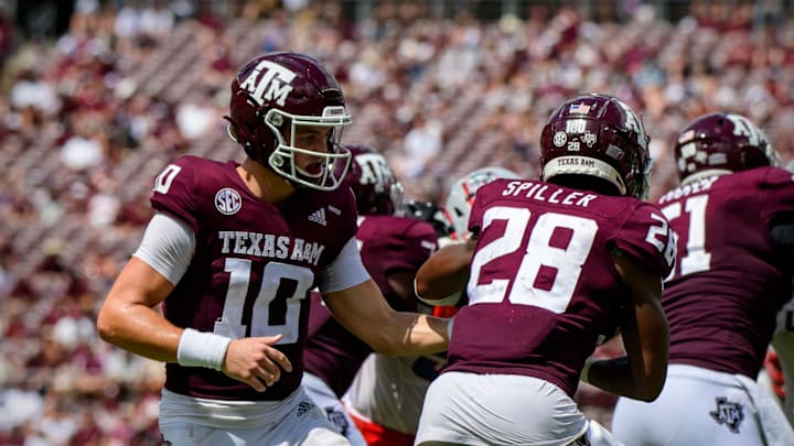 Sep 18, 2021; College Station, Texas, USA; Texas A&M Aggies quarterback Zach Calzada (10) hands off to running back Isaiah Spiller (28) during the second half against the New Mexico Lobos at Kyle Field. Mandatory Credit: Jerome Miron-USA TODAY Sports