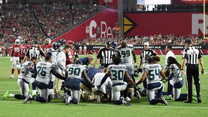 GLENDALE, AZ - SEPTEMBER 30: Members of the Seattle Seahawks kneel while trainers tend to defensive back Earl Thomas #29 (not pictured) during the fourth quarter against the Arizona Cardinals at State Farm Stadium on September 30, 2018 in Glendale, Arizona. (Photo by Norm Hall/Getty Images)