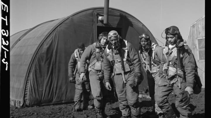 Tuskegee Airmen (left to right) Richard S. "Rip" Harder, unidentified airman, Thurston L. Gaines, Jr., Newman C. Golden, and Wendell M. Lucas leave the parachute room in Ramitelli, Italy, in March 1945.