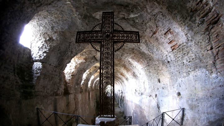 A cross stands in the Roman catacombs