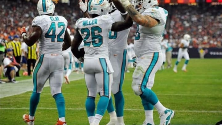 Aug 17, 2013; Houston, TX, USA; Miami Dolphins running back Lamar Miller (26) and fullback Charles Clay (42) and guard Richie Incognito (68) celebrate Miller