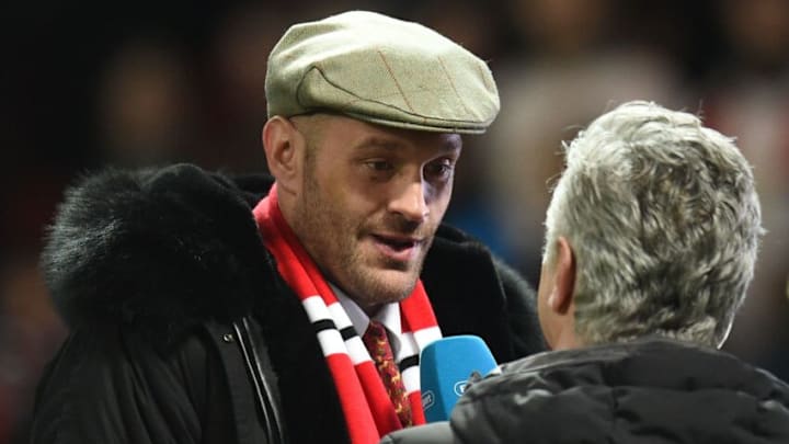 British boxer Tyson Fury is interviewed by a broadcaster on the pitch at half-time during the English Premier League football match between Manchester United and Arsenal at Old Trafford in Manchester, north west England, on December 5, 2018. (Photo by Oli SCARFF / AFP) / RESTRICTED TO EDITORIAL USE. No use with unauthorized audio, video, data, fixture lists, club/league logos or 'live' services. Online in-match use limited to 120 images. An additional 40 images may be used in extra time. No video emulation. Social media in-match use limited to 120 images. An additional 40 images may be used in extra time. No use in betting publications, games or single club/league/player publications. / (Photo credit should read OLI SCARFF/AFP via Getty Images)