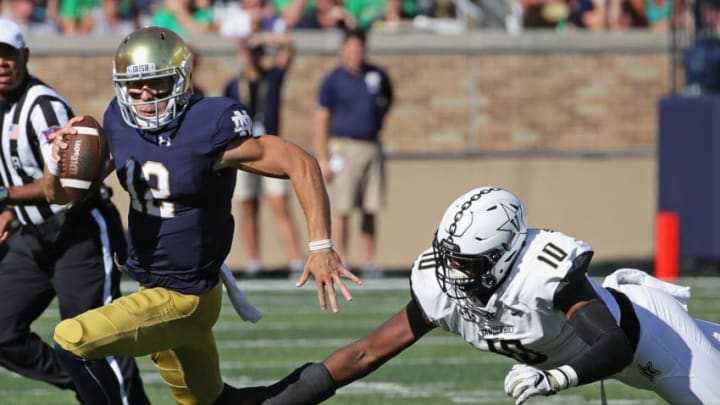 SOUTH BEND, IN - SEPTEMBER 15: Ian Book #12 of the Notre Dame Fighting Irish breaks away from Dayo Odeyingbo #10 of the Vanderbilt Commodoresat Notre Dame Stadium on September 15, 2018 in South Bend, Indiana. (Photo by Jonathan Daniel/Getty Images)