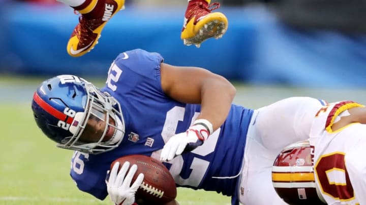 EAST RUTHERFORD, NJ - OCTOBER 28: Saquon Barkley #26 of the New York Giants is tackled in the fourth quarter against the Washington Redskins on October 28,2018 at MetLife Stadium in East Rutherford, New Jersey. (Photo by Elsa/Getty Images)