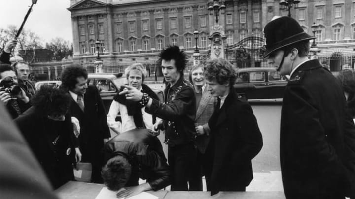 The Sex Pistols and their manager Malcolm McLaren signing a new contract with A&M Records, after being dropped from EMI, outside Buckingham Palace in 1977.