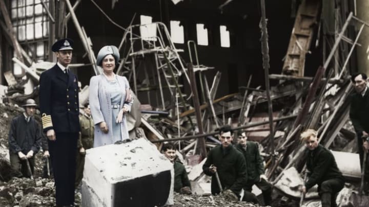 The King and Queen survey bomb damage at Buckingham Palace. The bombing destroyed the palace chapel.