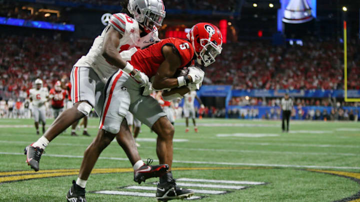 Dec 31, 2022; Atlanta, Georgia, USA; Georgia Bulldogs wide receiver Adonai Mitchell (5) makes a catch for a touchdown while defended by Ohio State Buckeyes cornerback Denzel Burke (10) to tie the game during the fourth quarter of the 2022 Peach Bowl at Mercedes-Benz Stadium. Mandatory Credit: Brett Davis-USA TODAY Sports