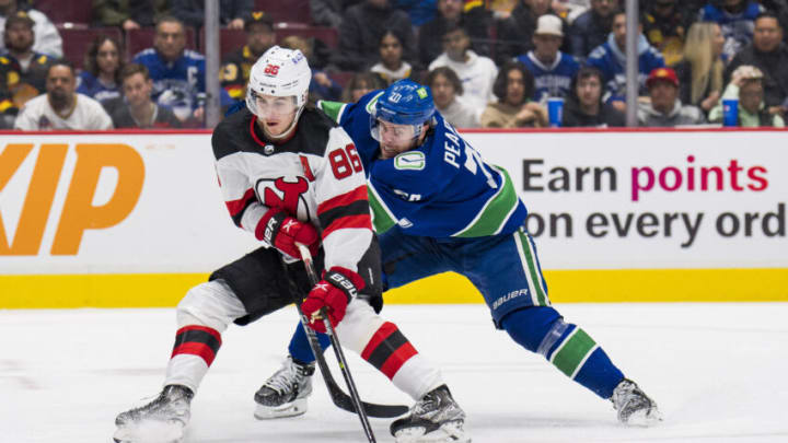 Mar 15, 2022; Vancouver, British Columbia, CAN; Vancouver Canucks forward Tanner Pearson (70) stick checks New Jersey Devils forward Jack Hughes (86) in the second period at Rogers Arena. Mandatory Credit: Bob Frid-USA TODAY Sports