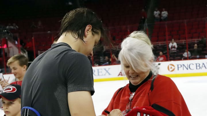 The Carolina Hurricanes’ Sebastian Aho gives his jersey to fan Sherry Hollcraft, right, at the end of a game against the New York Islanders at PNC Arena in Raleigh, N.C., on Thursday, April 6, 2017. It is a Hurricanes tradition where the team gives the shirts off their backs to lucky fans at one of the last games of the season. (Chris Seward/Raleigh News)