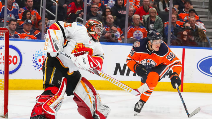 EDMONTON, AB – JANUARY 19: Calgary Flames Goalie David Rittich (33) shoots the puck out of the zone as Edmonton Oilers Right Wing Jesse Puljujarvi (98) reaches for it in the third period during the Edmonton Oilers game versus the Calgary Flames on January 19, 2019 at Rogers Place in Edmonton, AB. (Photo by Curtis Comeau/Icon Sportswire via Getty Images)