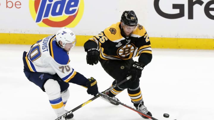 BOSTON, MA - JUNE 12: St. Louis Blues center Oskar Sundqvist (70) takes the puck from Boston Bruins right defenseman Brandon Carlo (25) during Game 7 of the Stanley Cup Final between the Boston Bruins and the St. Louis Blues on June 12, 2019, at TD Garden in Boston, Massachusetts. (Photo by Fred Kfoury III/Icon Sportswire via Getty Images)