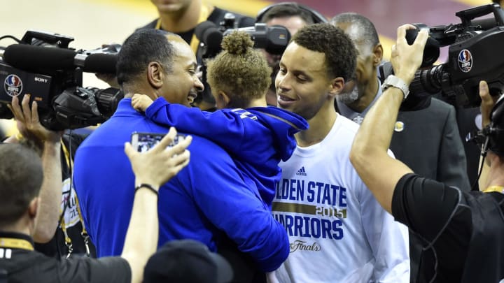 Jun 11, 2015; Cleveland, OH, USA; Golden State Warriors guard Stephen Curry (right) kisses his daughter Riley Curry (center) as she is held by his father Dell Curry after game four of the NBA Finals at Quicken Loans Arena. The Warriors won 103-82. Mandatory Credit: David Richard-USA TODAY Sports