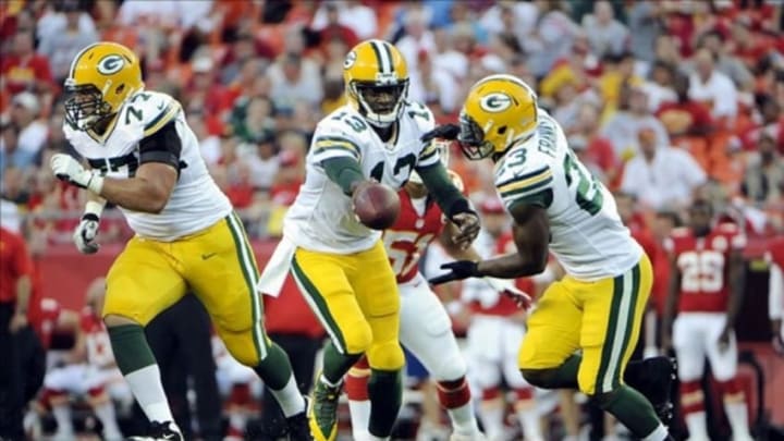 Aug 29, 2013; Kansas City, MO, USA; Green Bay Packers quarterback Vince Young (13) hands off to running back Johnathan Franklin (23) against the Kansas City Chiefs in the first half at Arrowhead Stadium. Mandatory Credit: John Rieger-USA TODAY Sports
