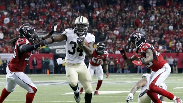 Jan 3, 2016; Atlanta, GA, USA; New Orleans Saints running back Tim Hightower (34) runs against Atlanta Falcons strong safety Kemal Ishmael (36) and cornerback Robert Alford (23) in the fourth quarter of their game at the Georgia Dome. The Saints won 20-17. Mandatory Credit: Jason Getz-USA TODAY Sports