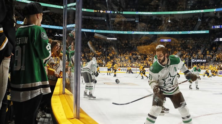 NASHVILLE, TENNESSEE – APRIL 20: Tyler Seguin #91 of the Dallas Stars flips a puck over the glass for a fan prior to Game Five of the Western Conference First Round against the Nashville Predators during the 2019 NHL Stanley Cup Playoffs at Bridgestone Arena on April 20, 2019 in Nashville, Tennessee. (Photo by Frederick Breedon/Getty Images)