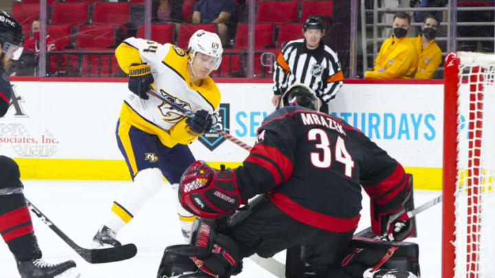 Apr 15, 2021; Raleigh, North Carolina, USA; Nashville Predators center Mikael Granlund (64) send the puck wide against Carolina Hurricanes goaltender Petr Mrazek (34) during the second period at PNC Arena. Mandatory Credit: James Guillory-USA TODAY Sports